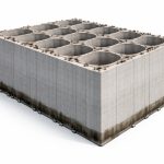 Offshore breakwater construction showing large reinforced concrete caisson installation on a prepared seabed using marine equipment and floating platforms