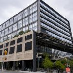 St John’s Terminal redevelopment showing a multi-storey vertical building expansion above a historic industrial structure with modern office floors and structural retrofit elements.
