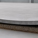 Concrete slab curling in an industrial warehouse showing lifted slab edges and joint deformation caused by differential drying shrinkage and moisture gradients.